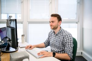 A man works at a computer in an office